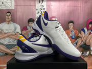 Angled view of the pair highlighting the lace-up construction, side Swoosh, purple outsole, and yellow heel detailing.