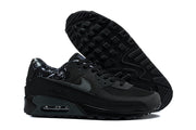 Black Nike Air Max 90 sneakers shown from the side and outsole.