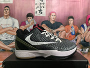 Side view of a black basketball shoe with a white Swoosh, textured upper, dark olive-toned heel panel, and white Zoom midsole.