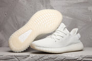 Pair of white Yeezy 350 V2 sneakers shown from the side and outsole views.