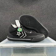 Black sneakers shown from above and underneath, highlighting the textured rubber outsole and side star detail.