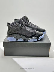 Side view of the black sneakers placed on a dark shoebox, showing ankle straps, textured upper sections, and translucent outsole areas.