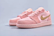 Angled product view showing both pink low-top sneakers and their gold side branding.