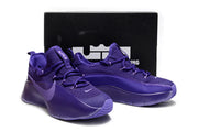 Pair of purple sneakers displayed in front of a black shoebox.