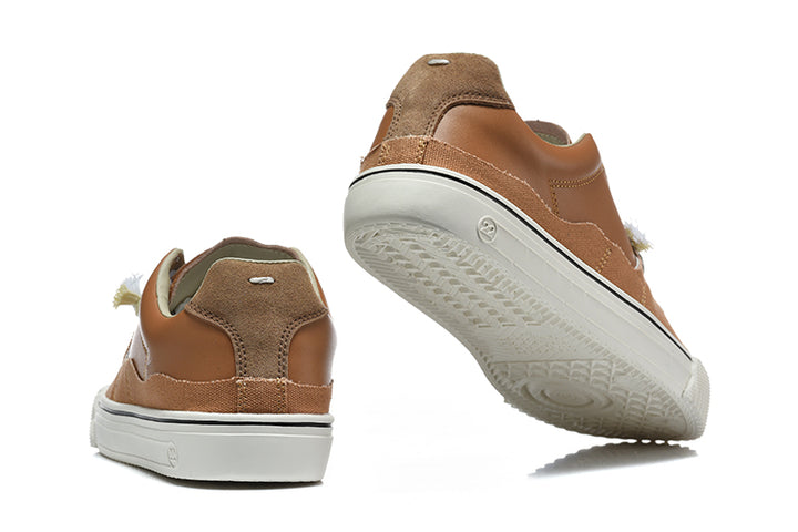 Brown and tan low-top sneakers shown from the heel and outsole.