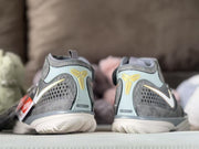 Rear view of the gray sneakers showing gold Kobe-style emblems, padded collars and textured heel outsoles.