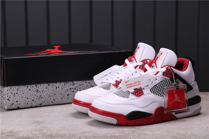 Pair of white, red, and black Jordan 4 Retro sneakers displayed with a Jordan shoebox.