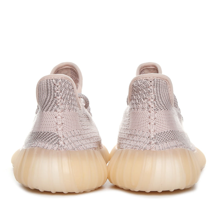 Rear view of taupe-pink knit sneakers showing padded collars and ribbed translucent gum-colored soles.