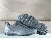 Black Alo sneakers displayed with one outsole facing upward, showing the geometric lug pattern and tread layout.