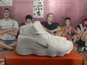 Side view of a white and silver Nike high-top basketball sneaker showing the textured upper, side Swoosh, and ridged sole.