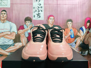 Front view of pink Nike basketball shoes with black laces