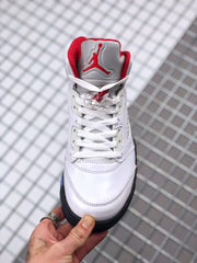 Front view showing white laces, a red Jordan tongue logo, red collar lining, and the high-top shape.