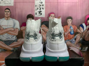 Rear view of white high-top basketball shoes with dark heel logos and teal outsoles