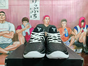 Front view of black and white Kobe Gigi basketball shoes with white laces and textured uppers.