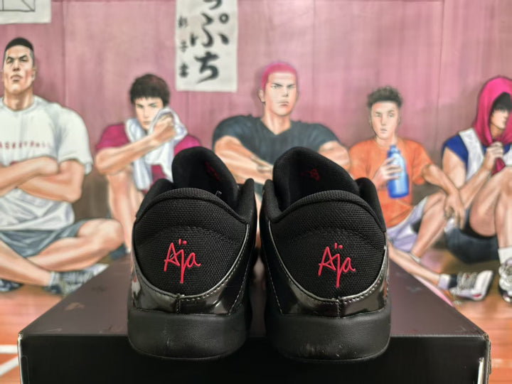 Rear view of black basketball shoes with red heel signatures and padded collars.