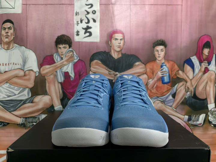 Front view of blue Nike basketball sneakers with blue laces, white textured soles, and a basketball-themed illustrated background.