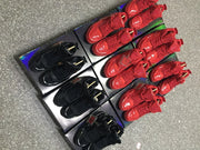Overhead display of red and black sneaker pairs placed on patterned boxes.