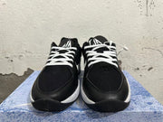 Front view of black basketball shoes with white laces and tongue logos