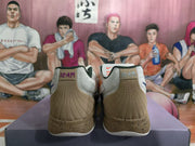 Rear view showing tan heel panels, vertical stitching, 12·AM branding, and speckled tan midsoles.