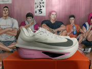 Side view showing black branding and pink midsole accent
