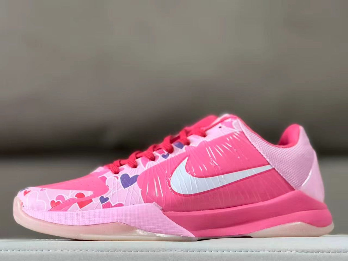 Side view of pink Nike Kobe 5 shoes with heart graphics and a white Swoosh