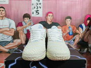 Front view of white Nike basketball sneakers with white laces, textured uppers, and light blue tongue details.