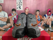 Front view of gray high-top sneakers showing black toe panels, orange-accented side details, and zip-style upper construction.