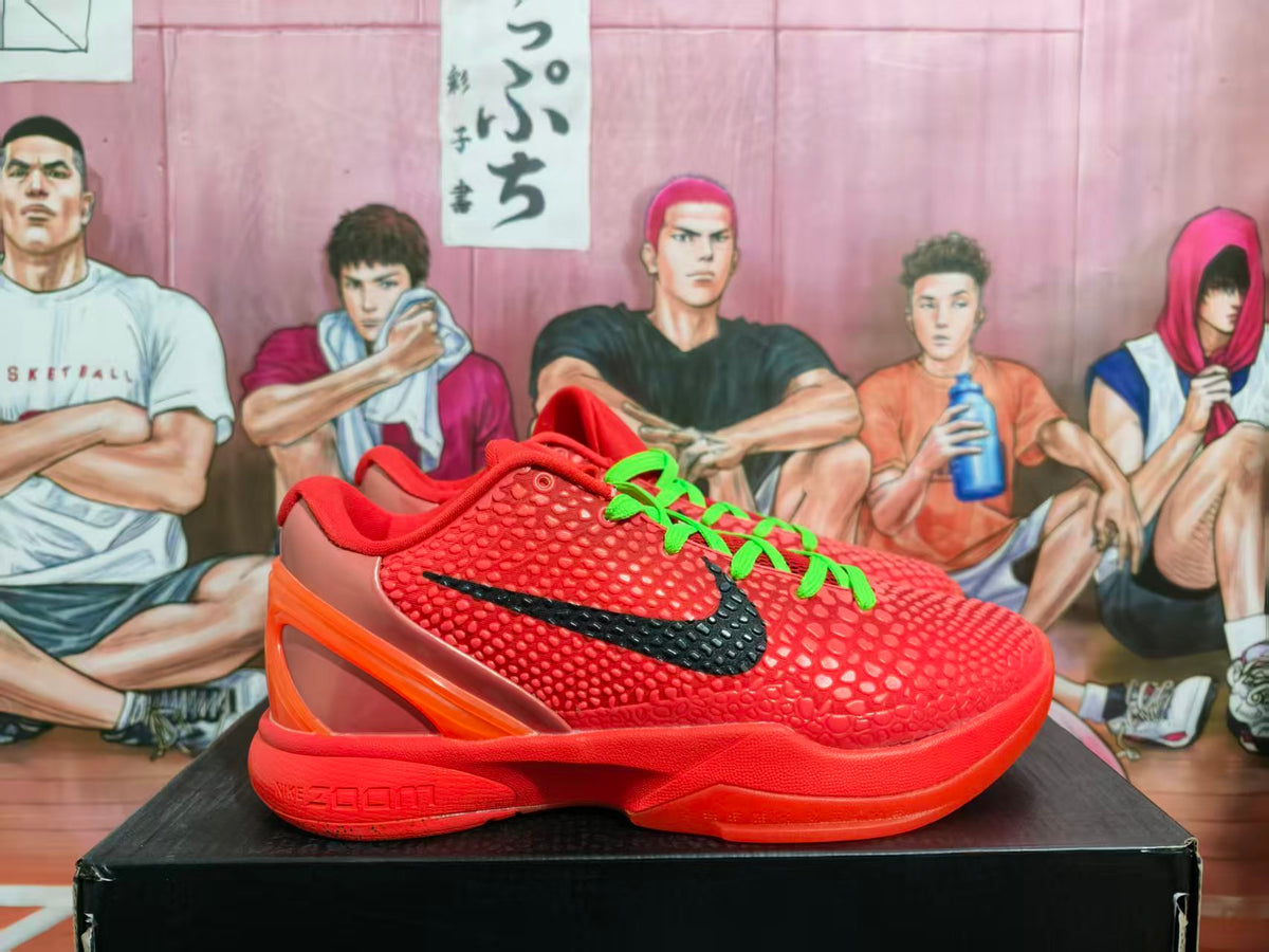 Side view of a red-orange Nike basketball shoe with a black swoosh, green laces, textured upper, and sculpted heel.