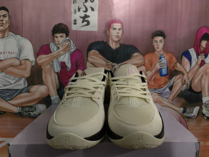 Front view of beige and black Nike basketball sneakers with pink accents and a basketball-themed illustrated backdrop.