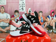 Angled view showing the pink and black Nike sneakers, white overlays, red outsole accents, and visible Swoosh.