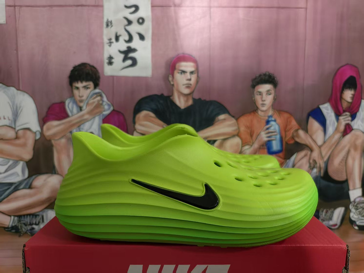 Side view of a bright green molded slip-on sneaker with a black side logo on a red Nike-branded box.