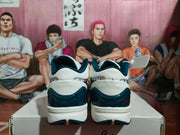 Rear view showing the white heel panels, dark blue heel accents, and layered soles of the sneakers.
