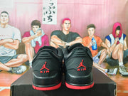 Rear view of black low-top sneakers with red heel branding and red outsole accents.