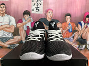 Front view of black and white basketball sneakers with textured uppers, white laces, tongue logos, and white toe accents.