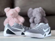 Pair of grey and white low-top basketball shoes shown at a front three-quarter angle.