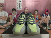 Front view of the sneaker pair showing lime green perforated toe panels, pink trim, and dark laces.