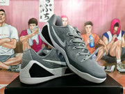 Angled view of gray low-top Kobe basketball shoes with white side logos