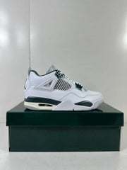 Side view of white and green Jordan Air Jordan 4 Retro sneakers displayed on a dark green shoebox.