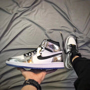 Side profile showing the Jordan winged logo, black Swoosh, white panels, and silver overlays.