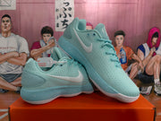 Angled view of a pair of mint green Nike sneakers displayed together, showing the Swoosh, laces and padded collars.