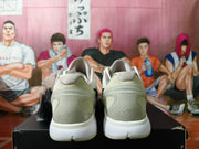 Rear view of white and light neutral basketball sneakers resting on a black box.