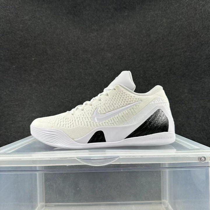 Side view of a white and black low-cut Nike basketball shoe with a textured upper and contrasting heel panels.