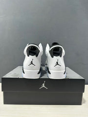 Rear view showing the heel branding, black collar details, and pull tabs on the white and black sneakers.