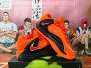 Orange and black Nike basketball shoes shown from the side and at an angle.