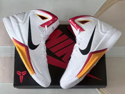 Top-down angled view of the pair on a black and red shoe box, showing black Swooshes and colored accents.