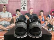 Rear view of the black and gray sneakers showing padded collars, gray heel panels, white outsole sections, and script-style heel details.