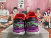 Rear view of purple and black Nike basketball shoes with green laces, red lining, and white outsoles.
