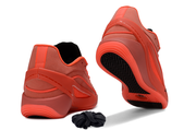 Bright red sneakers shown from the heel and outsole angles with black patterned tread.