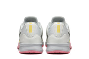 Rear view of the pale basketball shoes, showing yellow heel details and pink outsoles.