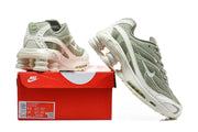 Pair of sage-green and white Nike Shox Ride 2 sneakers displayed with a red shoebox.